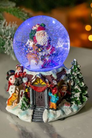 Снежный шар музыкальный ТАНЕЦ САНТЫ И РУДОЛЬФА, 2 меняющих цвета LED-огня, динамика, снежный вихрь, 21 см, батарейки, Kaemingk (Lumineo)